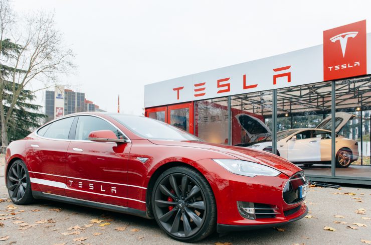 Tesla Modell vor einem Tesla Autohaus